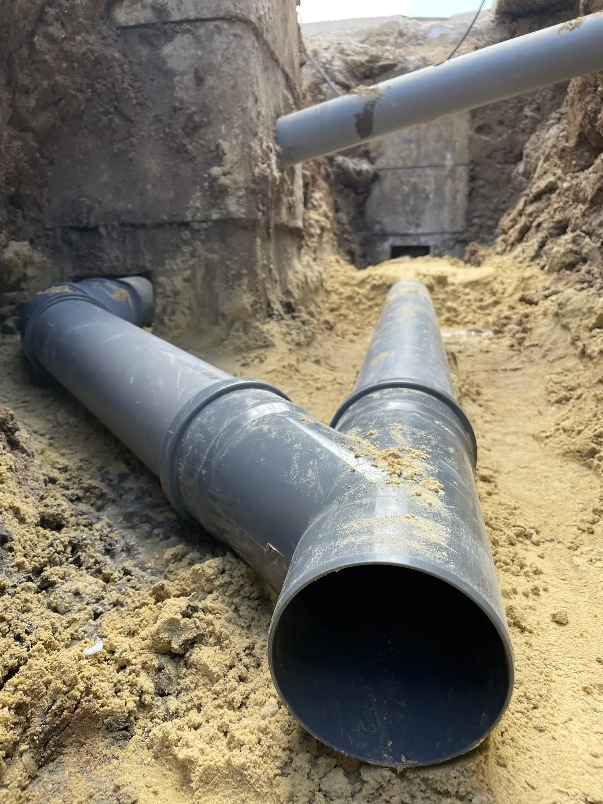 Pose d'une canalisation d'assainissement en tranchée sur un chantier en Essonne