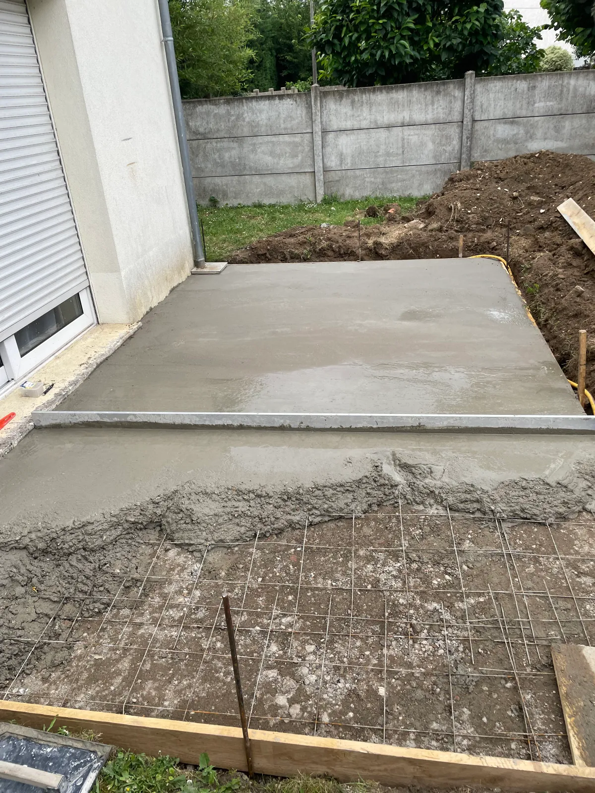 Dalle en béton fraîchement coulée par un maçon en Essonne