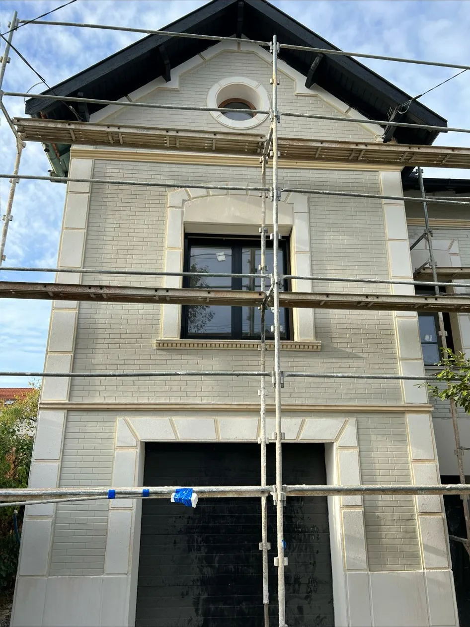 Pavillon en meulière et brique avec œil-de-bœuf, encadrements et chaînages d'angle repris en enduit clair